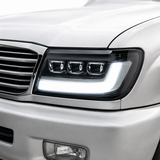 LandCruiser 100 Series bi-LED headlight installed — driver side close-up showing projector lens and DRL