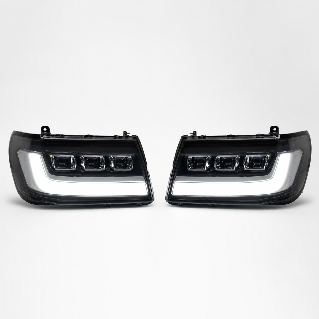 LandCruiser 100/105 Series bi-LED headlights — left and right pair on white background